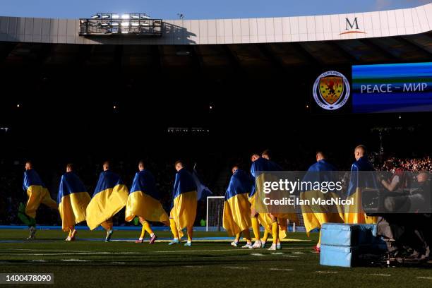 Ukraine players enter the pitch wearing their countries flag prior to the FIFA World Cup Qualifier match between Scotland and Ukraine at Hampden Park...