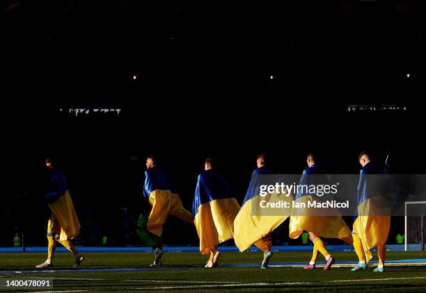 Ukraine players enter the pitch wearing their countries flag prior to the FIFA World Cup Qualifier match between Scotland and Ukraine at Hampden Park...