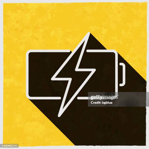 battery charging. icon with long shadow on textured yellow background - wireless charging stock illustrations