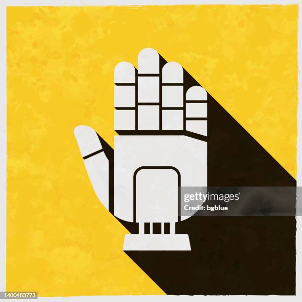 robot hand. icon with long shadow on textured yellow background - robotic process automation stock illustrations