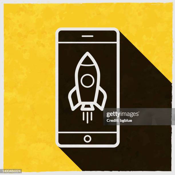 smartphone with rocket. icon with long shadow on textured yellow background - outdated smartphone stock illustrations