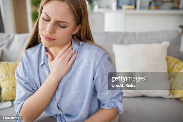 a woman holding her neck. neck pain. - human neck stock pictures, royalty-free photos & images