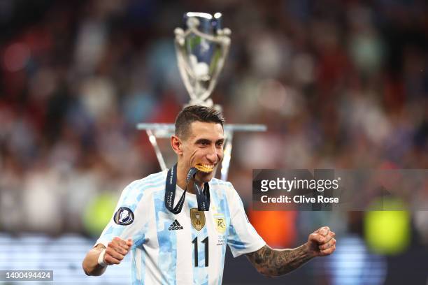 Angel Di Maria of Argentina bites on their winners medal as they walk to the podium after the final whistle of the 2022 Finalissima match between...