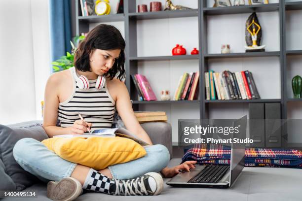 teenager-studentin mit drahtlosen kopfhörern, das zu hause studiert - student girl using laptop computer and smart phone stock-fotos und bilder