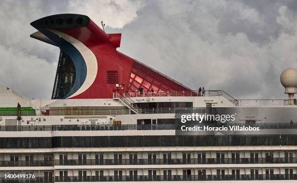 Passengers are seen on the upper deck as Carnival Pride, a Spirit-class cruise ship operated by Carnival Cruise Line, sails the Tagus River after...