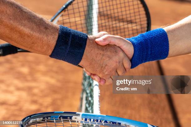 joueurs se serrant la main après le match de tennis - filet de tennis photos et images de collection