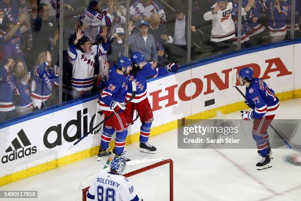 Chris Kreider of the New York Rangers celebrates with his teammates Mika Zibanejad and Frank Vatrano after scoring a goal on Andrei Vasilevskiy of...