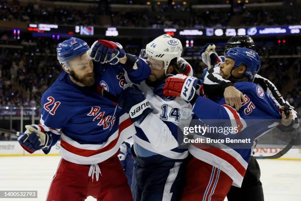 Barclay Goodrow and Ryan Reaves of the New York Rangers fight with Pat Maroon of the Tampa Bay Lightning during the third period in Game One of the...