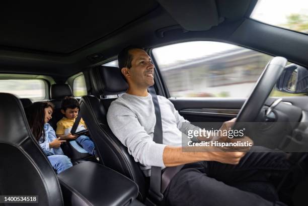 glücklicher vater, der seine kinder zur schule fährt - young child car driving stock-fotos und bilder
