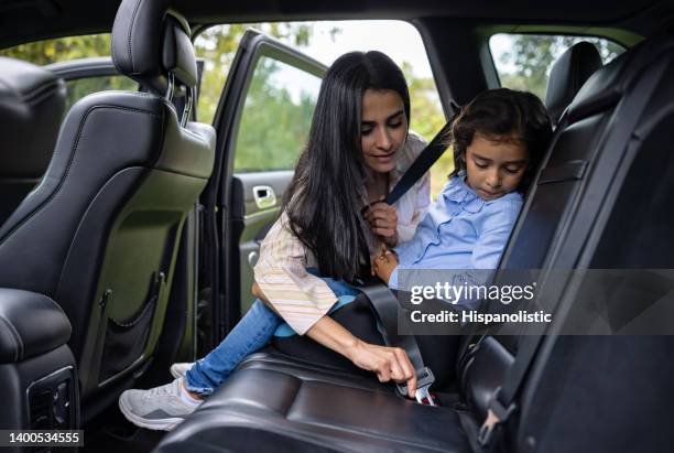 mutter schnallt den sicherheitsgurt ihrer tochter an - seat belt stock-fotos und bilder