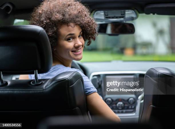 female drive looking over the shoulder to the passenger - uber driver stock pictures, royalty-free photos & images