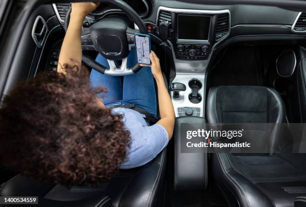 woman using the gps while driving a car - automatic gearshift stock pictures, royalty-free photos & images