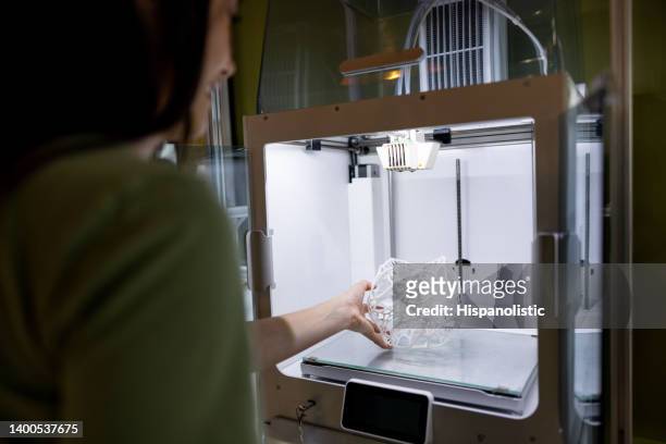 frau, die ein 3d-gedrucktes design aus dem drucker herausnimmt - 3d printer female stock-fotos und bilder