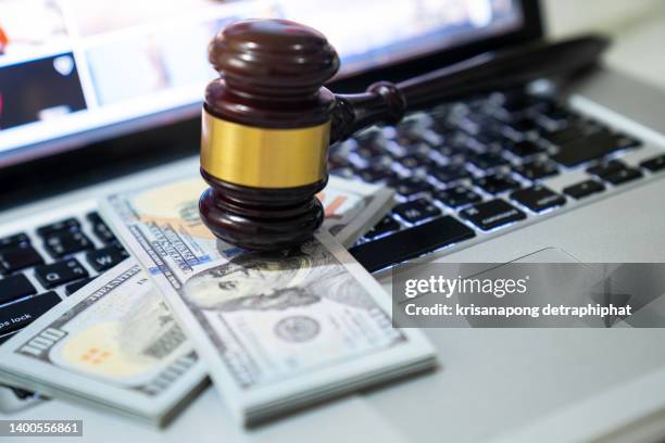 us paper currency on laptop and gavel,money with a hammer - cash bribe ストックフォトと画像