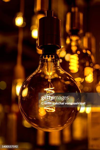 illuminated pendant lights hanging from ceiling - glass pendant light stock pictures, royalty-free photos & images