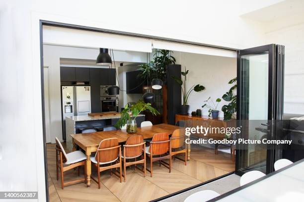 zona pranzo della casa moderna accanto alle porte aperte che conducono ad un patio - porta scorrevole foto e immagini stock