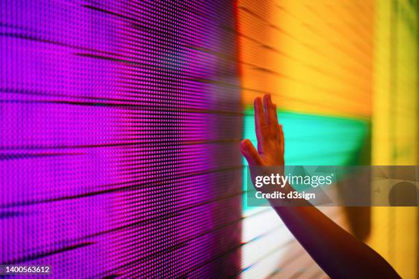 close up of a kid's hand touching illuminated and multi-coloured led display screen, connecting to the future concept - pantalla plasma fotografías e imágenes de stock