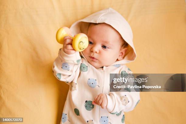 baby playing with a rattle - baby rattle stock pictures, royalty-free photos & images