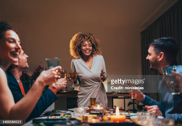 multi-ethic group of friends having fun at dinner table - party host stock pictures, royalty-free photos & images