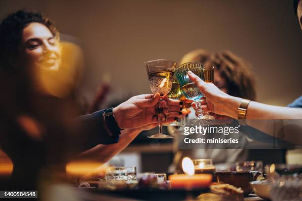 friends toasting with a glass of wine during a dinner celebration - lap of honour stockfoto's en -beelden