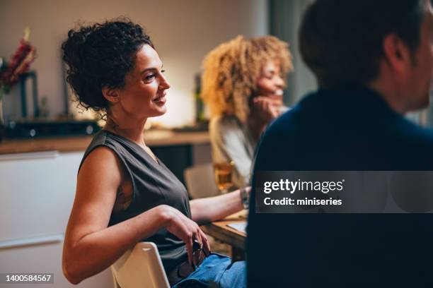 amigos sonrientes divirtiéndose durante una cena de celebración - woman party fotografías e imágenes de stock