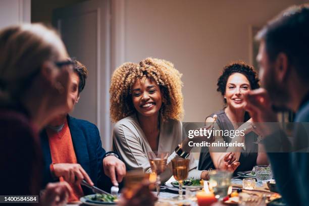 group of friends having fun during a dinner celebration - man and woman eating dinner stock pictures, royalty-free photos & images