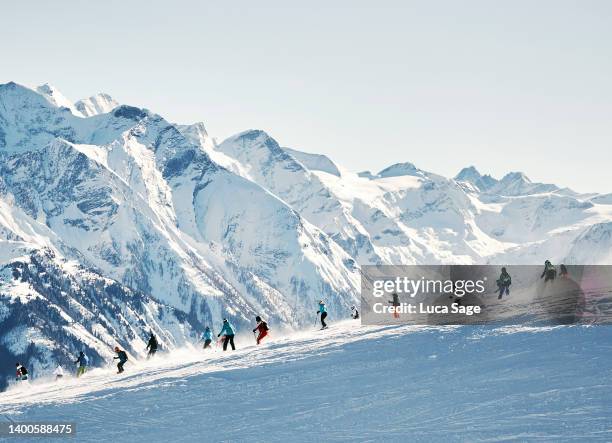 skiers with amazing mountain range in the background - skiing mountain stock pictures, royalty-free photos & images