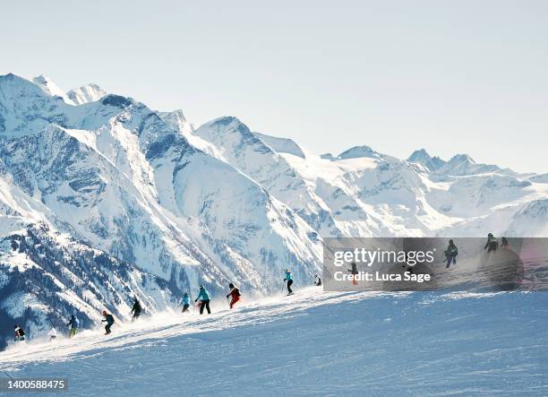 skiers with amazing mountain range in the background - mountain snow skiing stock pictures, royalty-free photos & images