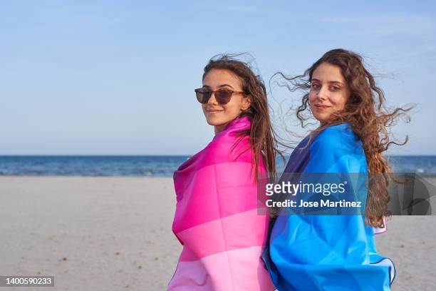 two women on the beach enjoying their summer vacations - toalla stock pictures, royalty-free photos & images