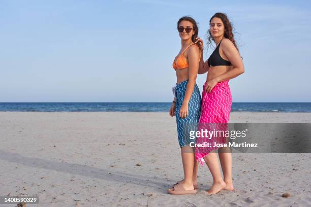two women on the beach enjoying their summer vacations - toalla stock pictures, royalty-free photos & images