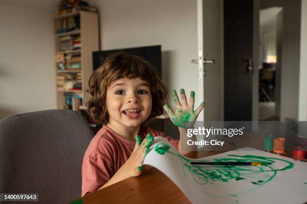 little boy fingerpainting at home - vingerverf stockfoto's en -beelden