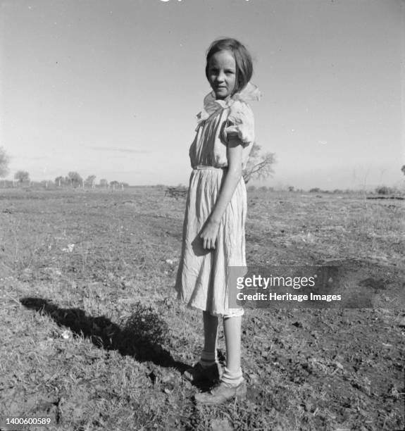 Resettled child of Bosque Farms, New Mexico. She herds cows for neighboring families for five cents per day. Artist Dorothea Lange.