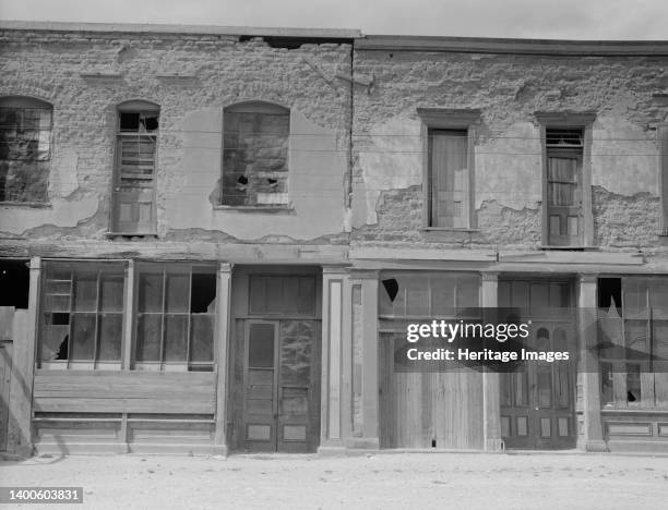 Crumbling buildings in Tombstone, Arizona, once a thriving mining town. Artist Dorothea Lange.