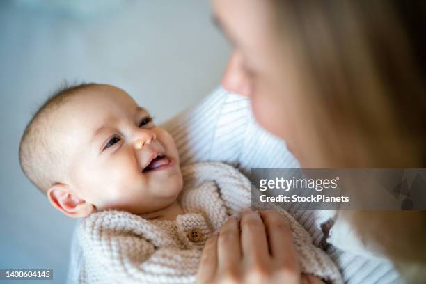 woman carrying her baby girl at home - smiling baby stock pictures, royalty-free photos & images