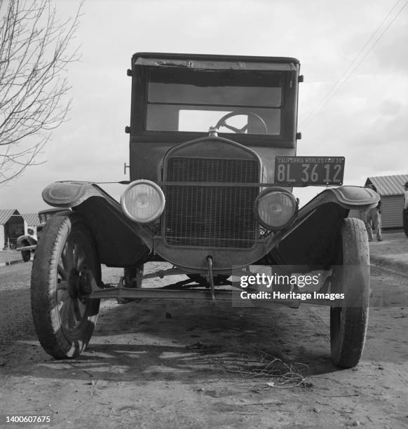 In Farm Security Administration migratory labor camp at Farmersville, California. Model T Fords still carry migrants. Artist Dorothea Lange.