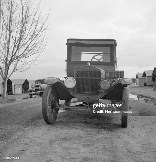 In Farm Security Administration migratory labor camp at Farmersville, California. Model T Fords still carry migrants. Artist Dorothea Lange.