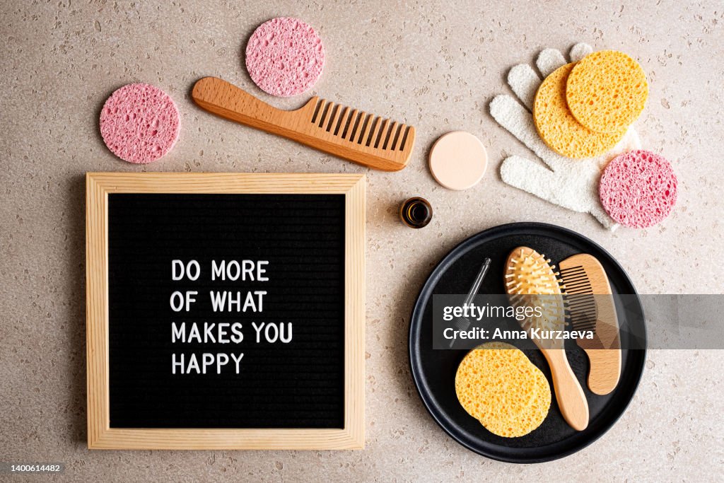 Set Of Ecofriendly Hair And Body Essentials On A Black Tray And A Letter  Board With Text Do More Of What Makes You Happy On Concrete Background Top  View Spa At Home