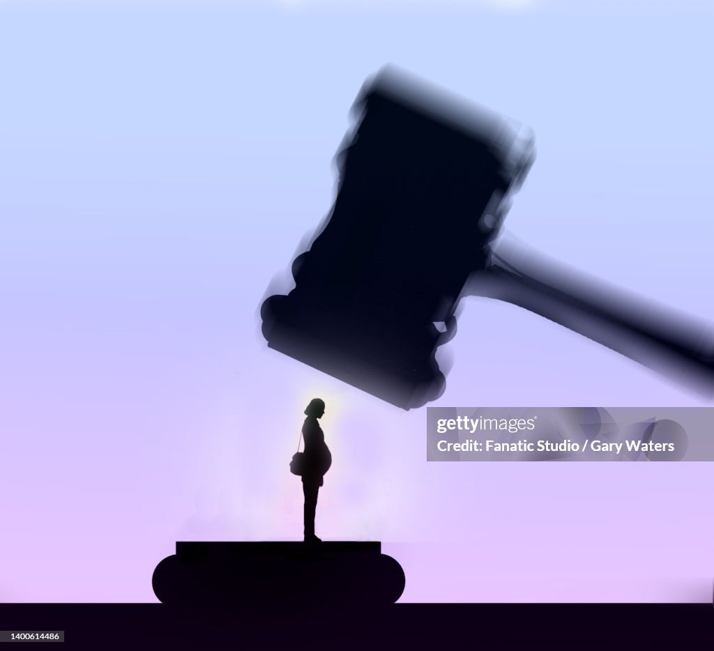 Concept image of a judges hammer coming down on a pregnant woman depicting abortion laws