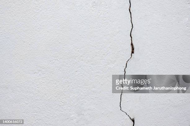 the white wall is breaking because of an earthquake. - cracked stockfoto's en -beelden