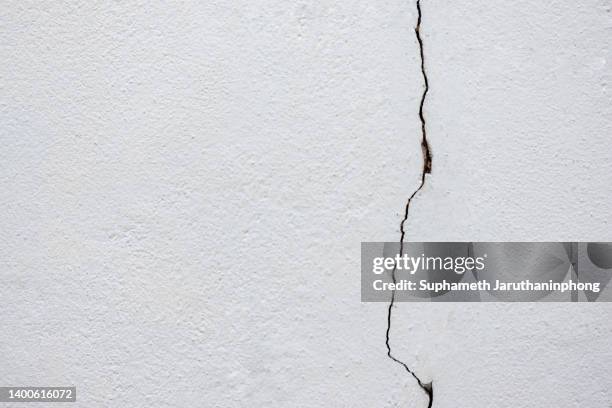 the white wall is breaking because of an earthquake. - cracked plaster stock pictures, royalty-free photos & images