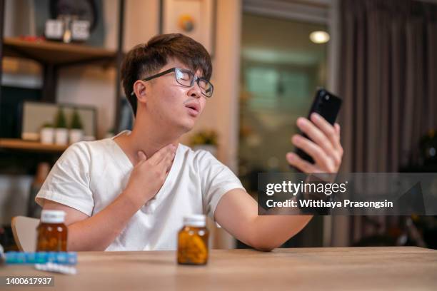 young man using smartphone to video conference to consulting about male hormone and physical with specialist and listen explaining at home for telemedicine health technology life concept - cellphone cancer illness stock-fotos und bilder