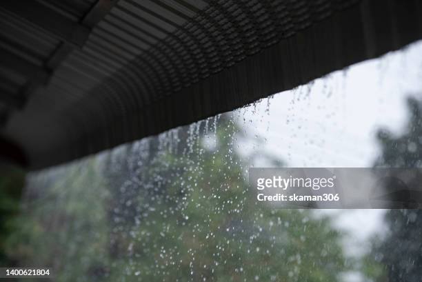 raining season heavy raining falling roof top  of the house - home disaster fotografías e imágenes de stock