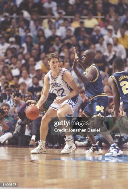 Ray Jackson of the Michigan Wolverines tries to guard center Christian Laettner of the Duke Blue Devils during a playoff game at the Hubert H....