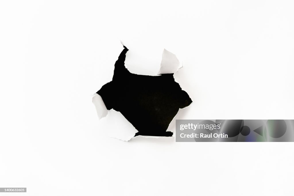 Big hole in white torn paper