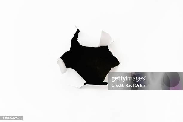 big hole in white torn paper - loch stock-fotos und bilder
