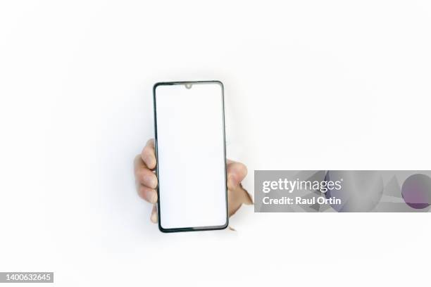 hand holding smartphone , showing empty white screen through white paper. - cracked iphone stock pictures, royalty-free photos & images