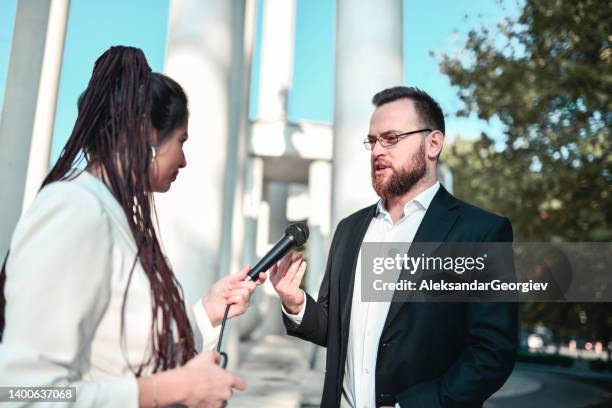 serious female reporter waiting for male politician to answer the question she asked - political press conference stock pictures, royalty-free photos & images