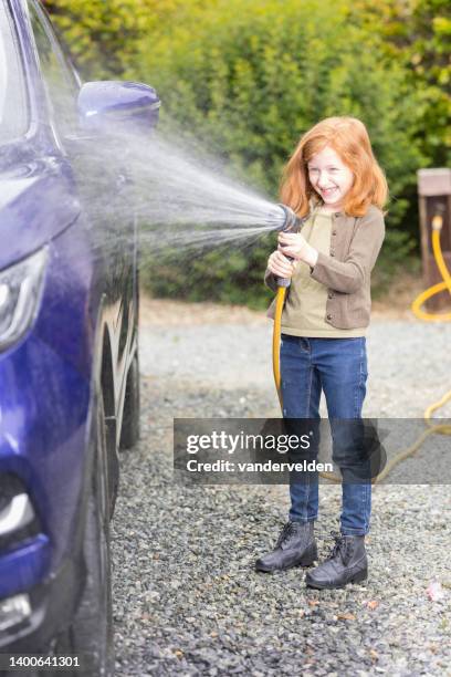 cheerful little girl cleaning daddy's car - girl wearing boots stock pictures, royalty-free photos & images