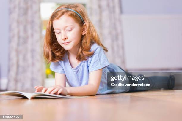 ラウンジで読書をする7歳の少女 - カチューシャ ストックフォトと画像