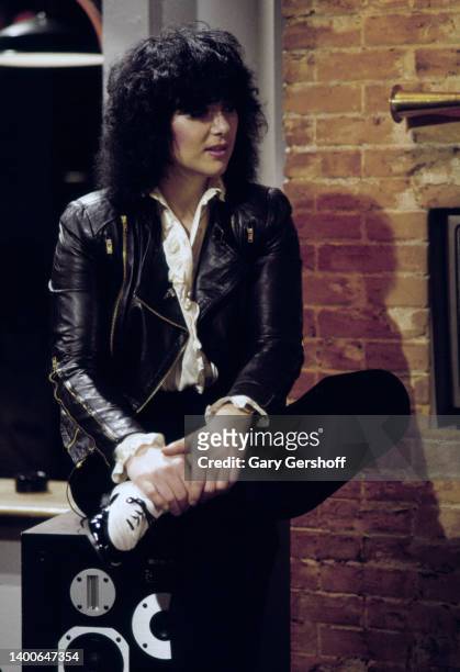 View of American Rock musician Ann Wilson, of the group Heart, seated on a stereo speaker during an interview on MTV at Teletronic Studios, New York,...